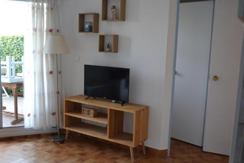 un salon avec une télévision à écran plat et une table dans l'établissement Appartement Saint Cyprien t2 rez de jardin résidence les capitelles, à Saint-Cyprien