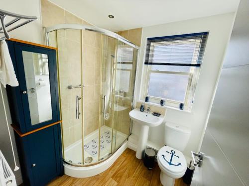 a bathroom with a shower and a toilet and a sink at Captains Rest - 2 bedroom apartment in the heart of Brixham in Brixham