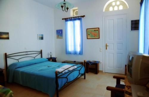 a bedroom with a blue bed and a tv at Karyatides Homes in Kariá
