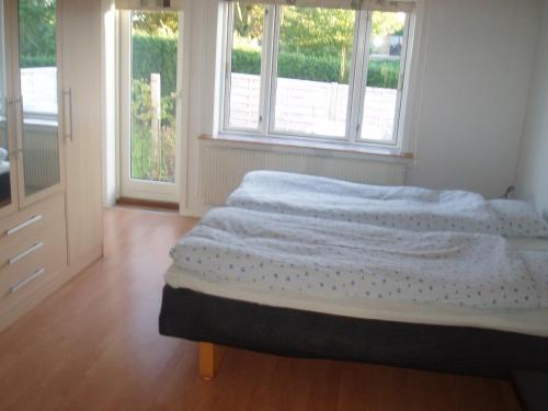 um quarto com 2 camas e 2 janelas em Tødsø Bed & Bath Holiday Home em Nykobing Mors