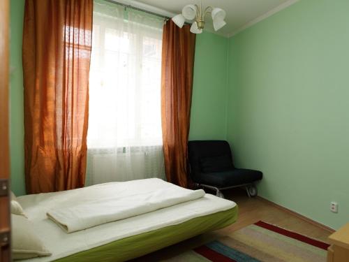 a bedroom with a bed and a window with a chair at 7k-Zamecky Vrch 2 in Karlovy Vary