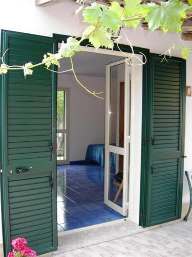 an open doorway to a room with green doors at Villa Verdemare Naxos in Giardini Naxos
