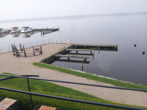 a view of a dock with a boat in the water at Bootshaus Neustrelitz in Neustrelitz