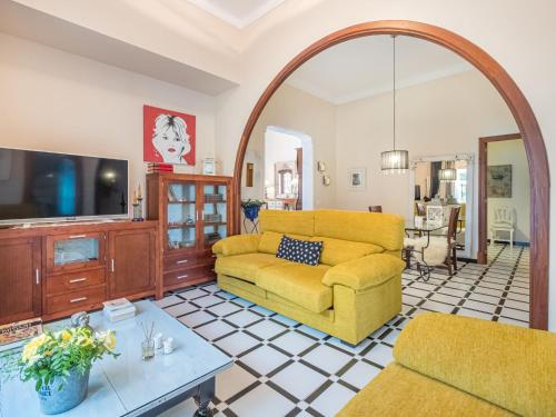 a living room with a yellow couch and a tv at Holiday Home Mare by Interhome in Ses Salines