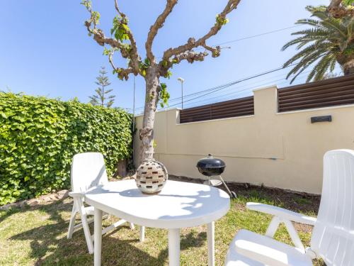 une table et des chaises dans une cour avec un arbre dans l'établissement Apartment L'Estel by Interhome, à Torredembarra