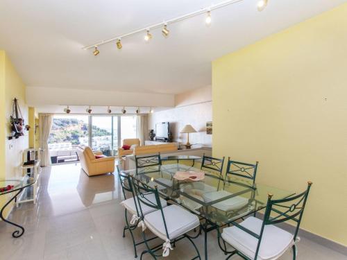 ein Wohnzimmer mit einem Glastisch und Stühlen in der Unterkunft Apartment Cala del mar by Interhome in Tossa de Mar