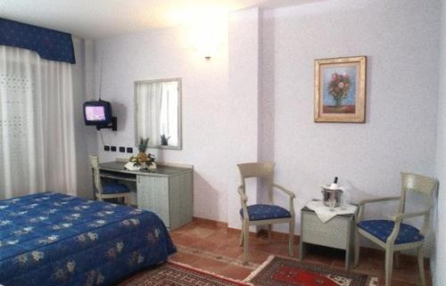 a bedroom with a bed and a desk and chairs at Hotel San Giorgio in Sangano