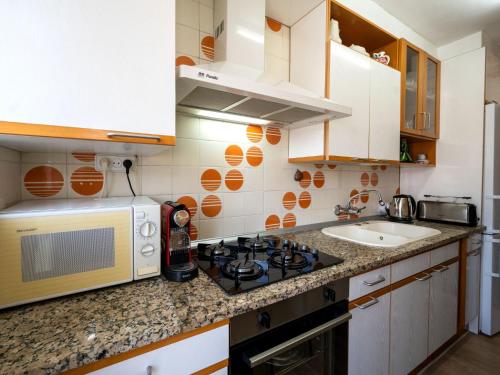 a small kitchen with a stove and a microwave at Apartment Riumar by Interhome in Segur de Calafell