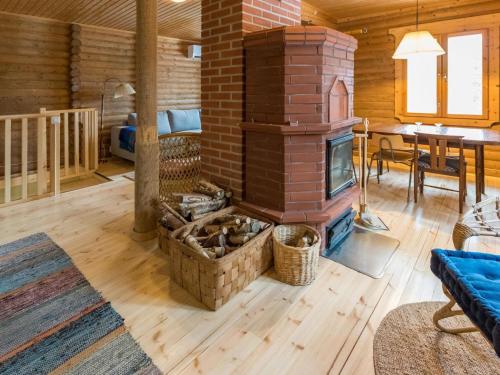 a living room with a brick fireplace in a log cabin at Holiday Home Hiljanrinne by Interhome in Haminankylä