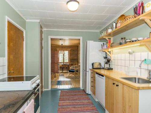 a kitchen with a sink and a refrigerator at Holiday Home Hiljanrinne by Interhome in Haminankylä