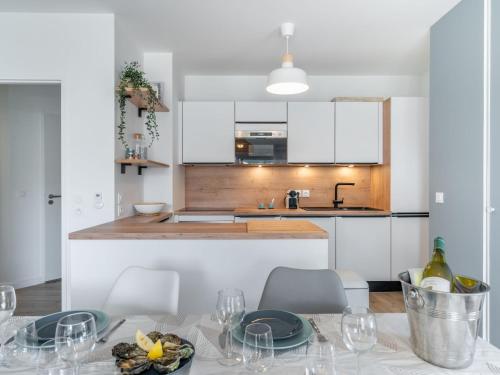 una cocina con una mesa con copas de vino. en Apartment Les Villas du Men Du-1 by Interhome en Carnac