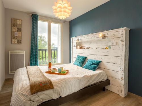 um quarto com uma cama grande e uma cabeceira em madeira em Apartment Les Corniches du Mont Canisy by Interhome em Blonville-sur-Mer