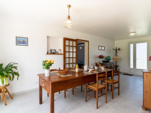 a dining room with a wooden table and chairs at Holiday Home l'Emeraude by Interhome in Matignon