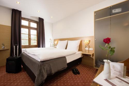 a hotel room with a large bed and a window at Hotel Landgasthof König von Preussen in Marxzell
