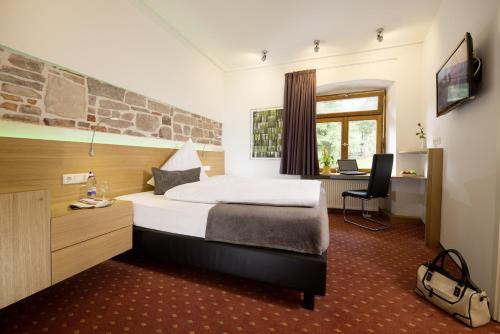 ein Hotelzimmer mit einem Bett und einem Schreibtisch in der Unterkunft Hotel Landgasthof König von Preussen in Marxzell