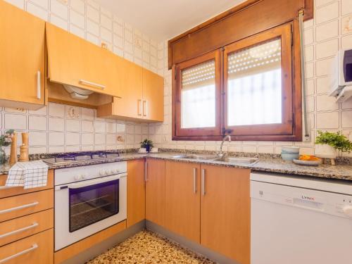 a kitchen with wooden cabinets and white appliances at Holiday Home Ibicenca by Interhome in Riumar