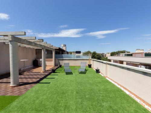 薩洛的住宿－Apartment Bosc de la Montserrada by Interhome，屋顶上带椅子和草地的天井