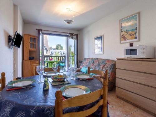 une salle à manger avec une table et une cuisine dans l'établissement Apartment Fleur Marine-30 by Interhome, à Cabourg