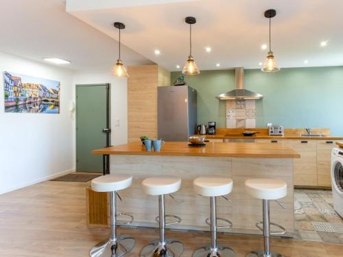 - une cuisine avec un bar avec des tabourets devant dans l'établissement Apartment Cap Cabourg-29 by Interhome, à Cabourg