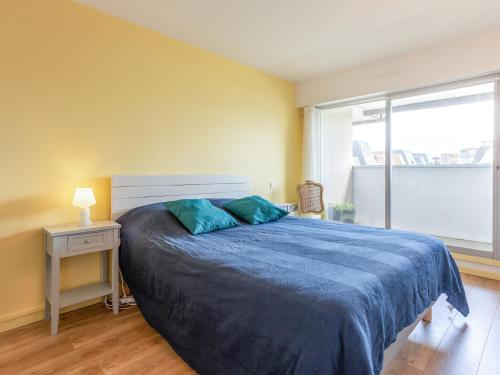 une chambre avec un lit avec des draps bleus et une fenêtre dans l'établissement Apartment Cap Cabourg-29 by Interhome, à Cabourg