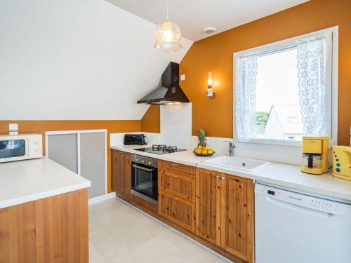 une cuisine avec des armoires en bois et une fenêtre dans l'établissement Apartment Kerisper by Interhome, à La Trinité-sur-Mer