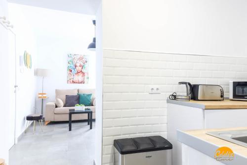 a kitchen and a living room with a couch at Casa Rehala by Cadiz Time in Cádiz