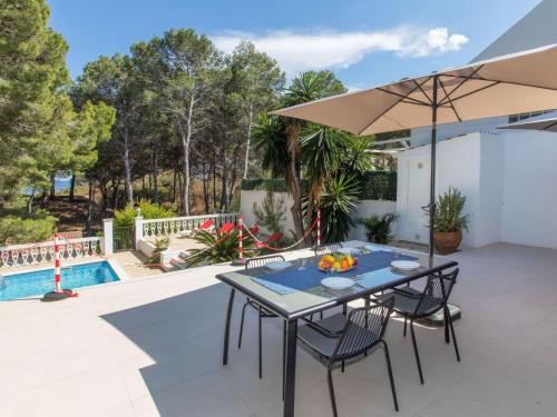 une terrasse avec une table, des chaises et un parasol dans l'établissement Villa Marina by Interhome, à L'Ametlla de Mar