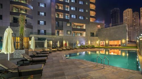 una piscina de hotel con tumbonas y un edificio en City Premiere Marina Hotel Apartments, en Dubái