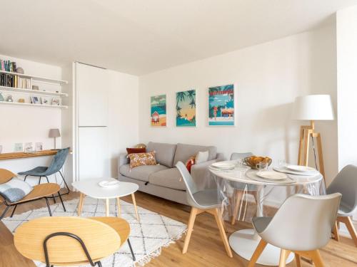 un salon avec un canapé, une table et des chaises dans l'établissement Apartment Les Hélianthes-2 by Interhome, à Lacanau-Océan