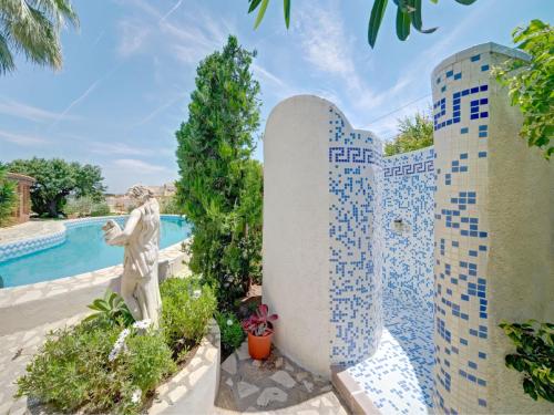 a statue in front of a wall with blue tiles at Apartment Doris by Interhome in Calpe