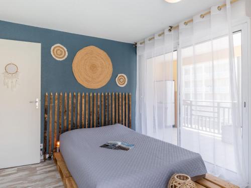 une chambre avec un lit et un mur bleu dans l'établissement Apartment Les jardins de l'oyat-1 by Interhome, à Mimizan