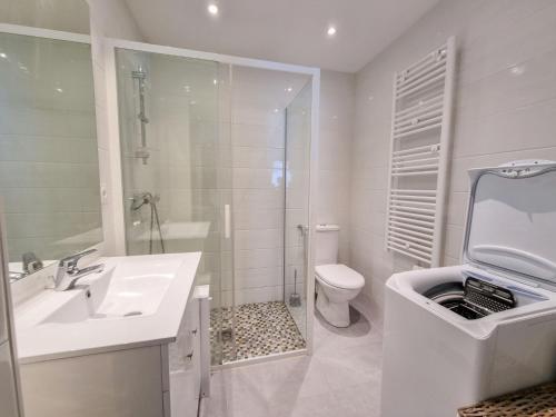une salle de bain blanche avec un lavabo et des toilettes dans l'établissement Apartment Les Figuiers by Interhome, à Dinard