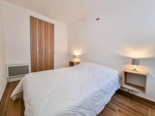 une chambre blanche avec un grand lit et une télévision dans l'établissement Apartment Les Figuiers by Interhome, à Dinard