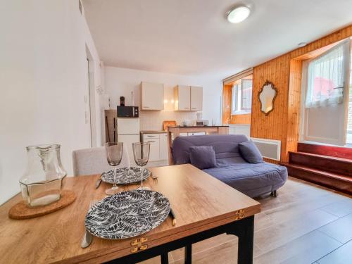 un salon avec une table et un canapé bleu dans l'établissement Apartment Les Figuiers by Interhome, à Dinard