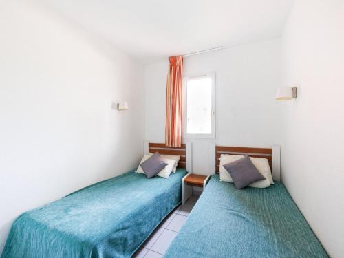 deux lits dans une petite pièce avec une fenêtre dans l'établissement Apartment Primavera-2 by Interhome, au Cap d'Agde
