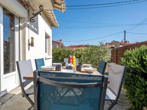 une table et des chaises bleues sur une terrasse dans l'établissement Holiday Home Les Violettes by Interhome, à Canet