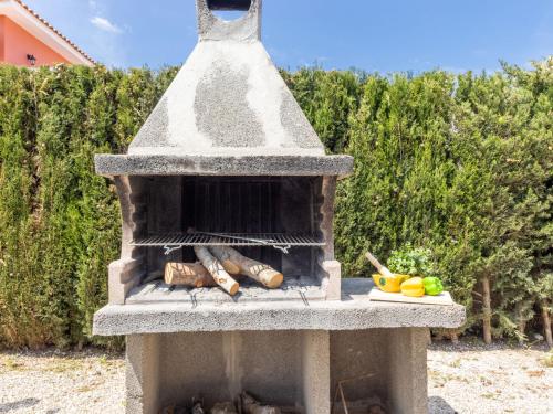 un horno de piedra al aire libre con comida en una mesa en Holiday Home Stefania by Interhome, en Riumar