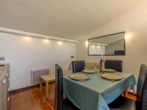 une table à manger avec un chiffon bleu et un miroir dans l'établissement Apartment Les Héliades-1 by Interhome, au Cap d'Agde