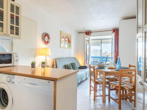 une cuisine et un salon avec une table et un canapé dans l'établissement Apartment Parc de la Mer-11 by Interhome, au Barcarès
