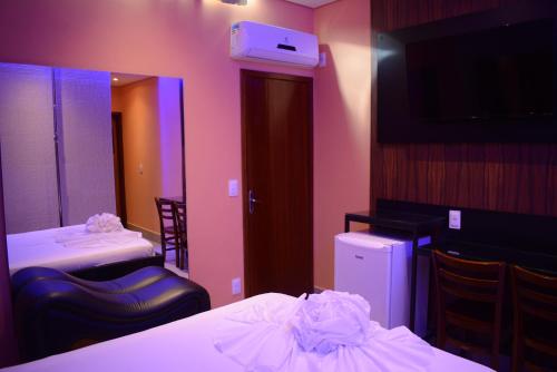 um quarto com duas camas e um espelho em Motel Sunny Day Betim em Betim