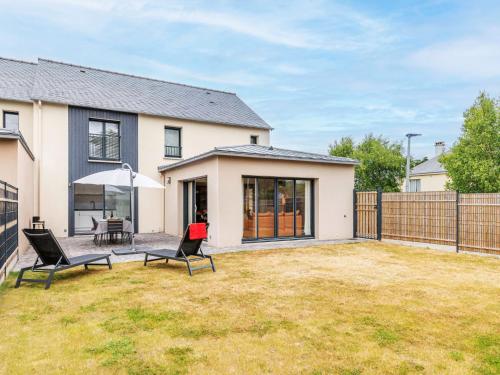 une arrière-cour avec deux chaises et un parasol dans l'établissement Holiday Home Maison les Dunes by Interhome, à Saint-Lunaire