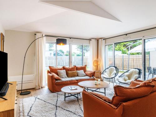 ein Wohnzimmer mit einem Sofa, Stühlen und einem Tisch in der Unterkunft Holiday Home Maison les Dunes by Interhome in Saint-Lunaire