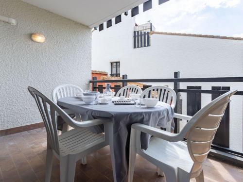 une table grise et des chaises sur un balcon dans l'établissement Apartment Coudalère-Les Hébrydes-1 by Interhome, au Barcarès