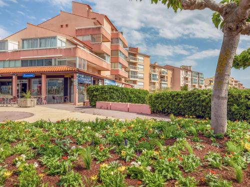 budynek z drzewem i ogrodem z kwiatami w obiekcie Apartment Port Plage 2 by Interhome w mieście Le Barcarès