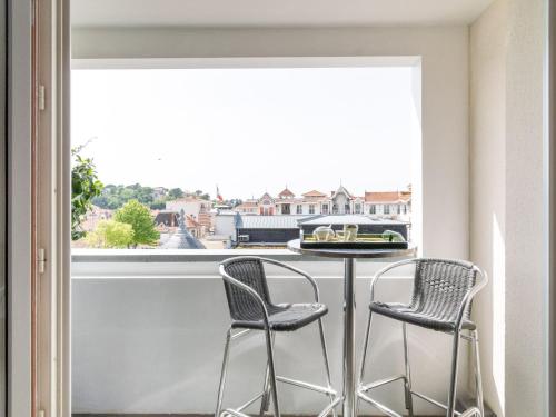 d'un balcon avec deux chaises et une table devant une fenêtre. dans l'établissement Apartment Maïlys by Interhome, à Arcachon