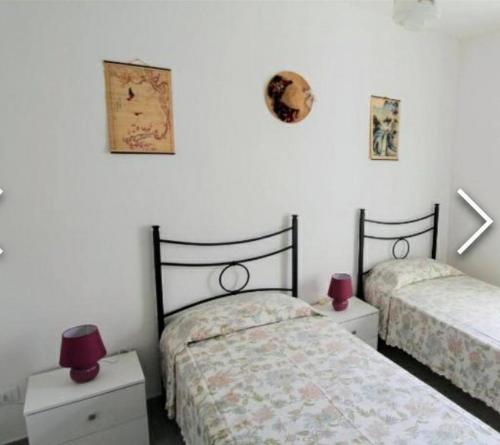 - une chambre avec 2 lits et 2 tables avec des bougies rouges dans l'établissement Casa Irma, à Chiusavecchia