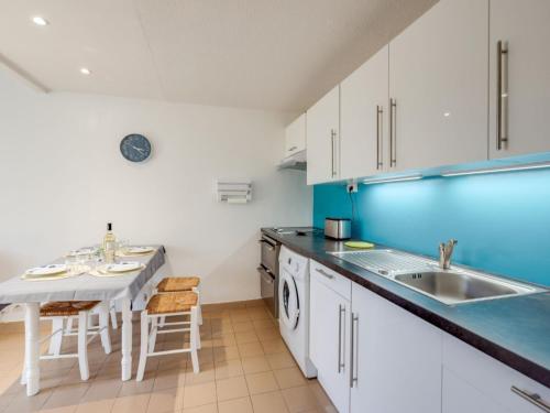 een keuken met een wastafel en een tafel bij Holiday Home Les mas Bleus by Interhome in Saint Cyprien Plage