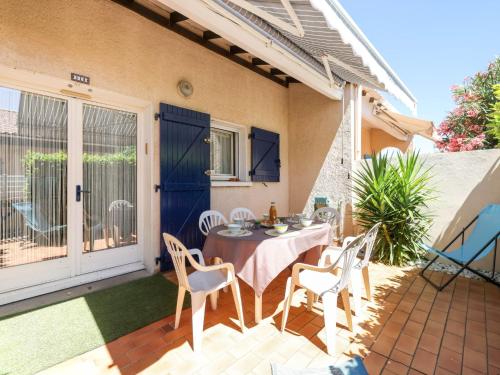 een tafel en stoelen op de patio van een huis bij Holiday Home Les mas Bleus by Interhome in Saint Cyprien Plage