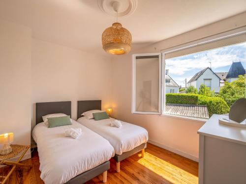 deux lits dans une chambre avec une grande fenêtre dans l'établissement Holiday Home Ti Erminig by Interhome, à Carnac