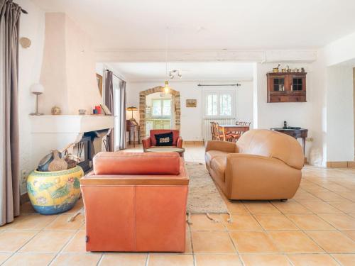 un salon avec deux canapés et une cheminée dans l'établissement Holiday Home Le Mas du Magnoglia by Interhome, à Tourtour